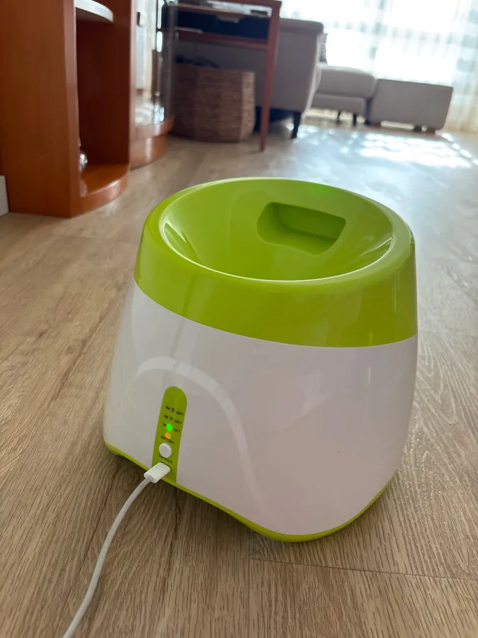 Le lanceur posé sur un parquet, câble de charge branché